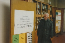 Paweł Podejko przy afiszach dotyczących uroczystości "Jubileuszu 80-lecia urodzin i 55-lecia pracy pedagogicznej i naukowej prof. dr Pawła Podejki"