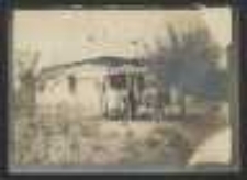 Fotografia plenerowa - siedzący mężczyzna przy stole ( A. Majkowski?) na tle domu